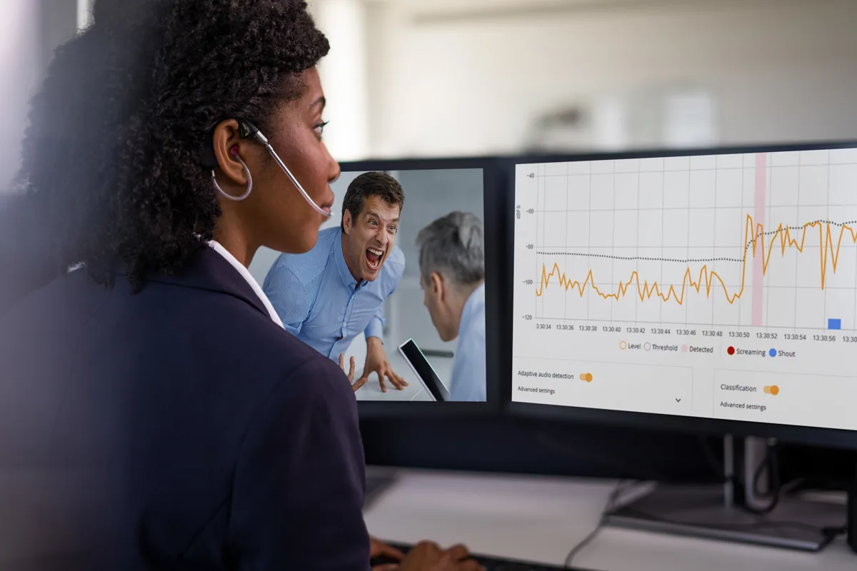 Security guard monitoring video analytics on multiple screens